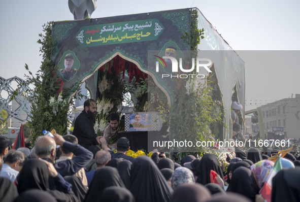 Iranian mourners take part in a funeral while a truck carries a coffin containing the body of a commander of the Islamic Revolutionary Guard...