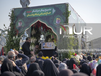 Iranian mourners take part in a funeral while a truck carries a coffin containing the body of a commander of the Islamic Revolutionary Guard...