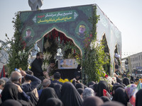 Iranian mourners take part in a funeral while a truck carries a coffin containing the body of a commander of the Islamic Revolutionary Guard...