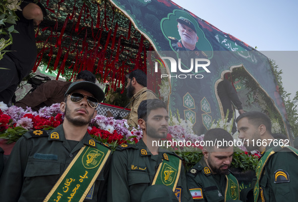 IRGC military personnel stand guard next to a truck carrying a coffin containing the body of a commander of the Islamic Revolutionary Guard...