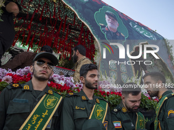 IRGC military personnel stand guard next to a truck carrying a coffin containing the body of a commander of the Islamic Revolutionary Guard...