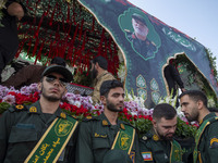 IRGC military personnel stand guard next to a truck carrying a coffin containing the body of a commander of the Islamic Revolutionary Guard...