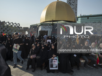 Iranian mourners hold portraits of Iran's Supreme Leader, Ayatollah Ali Khamenei, and a commander of the Islamic Revolutionary Guard Corps'...