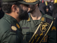 Two IRGC military personnel monitor an area during a funeral for a commander of the Islamic Revolutionary Guard Corps' (IRGC) Quds Force, Ab...