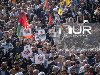 Iranian mourners hold portraits of a commander of the Islamic Revolutionary Guard Corps' (IRGC) Quds Force, Abbas Nilforoushan, who is kille...