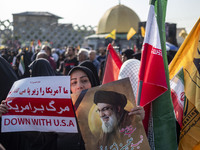 A veiled Iranian mourner holds a portrait of Lebanon's Hezbollah late leader, Hassan Nasrallah, and an anti-U.S. placard while taking part i...