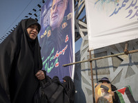 A veiled Iranian mourner holds a Palestinian flag and a portrait of Lebanon's Hezbollah leader, Hassan Nasrallah, while a veiled woman walks...