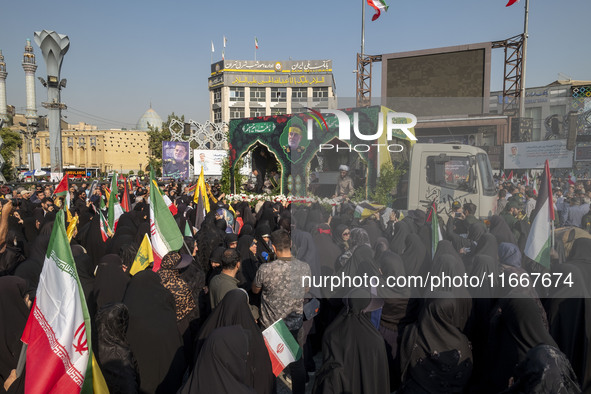 Iranian mourners take part in a funeral while a truck carries a coffin containing the body of a commander of the Islamic Revolutionary Guard...