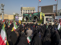 Iranian mourners take part in a funeral while a truck carries a coffin containing the body of a commander of the Islamic Revolutionary Guard...