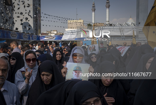 A veiled Iranian mourner holds a portrait of a commander of the Islamic Revolutionary Guard Corps' (IRGC) Quds Force, Abbas Nilforoushan, wh...