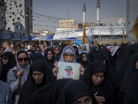 A veiled Iranian mourner holds a portrait of a commander of the Islamic Revolutionary Guard Corps' (IRGC) Quds Force, Abbas Nilforoushan, wh...