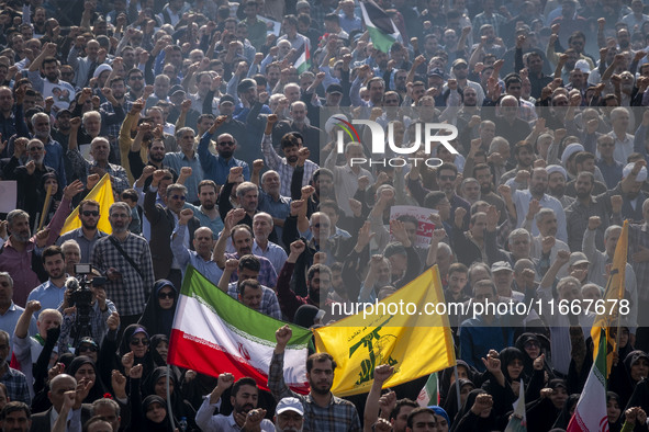 Iranian mourners shout anti-Israeli and anti-U.S. slogans while carrying an Iranian flag and a flag of Lebanon’s Hezbollah during a funeral...