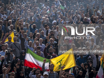 Iranian mourners shout anti-Israeli and anti-U.S. slogans while carrying an Iranian flag and a flag of Lebanon’s Hezbollah during a funeral...