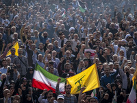 Iranian mourners shout anti-Israeli and anti-U.S. slogans while carrying an Iranian flag and a flag of Lebanon’s Hezbollah during a funeral...