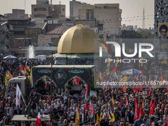 Iranian mourners take part in a funeral as a truck carries a coffin containing the body of a commander of the Islamic Revolutionary Guard Co...