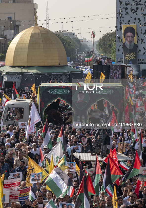 Iranian mourners participate in a funeral while a truck carrying a coffin containing the body of a commander of the Islamic Revolutionary Gu...