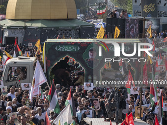 Iranian mourners participate in a funeral while a truck carrying a coffin containing the body of a commander of the Islamic Revolutionary Gu...