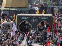 Iranian mourners participate in a funeral while a truck carrying a coffin containing the body of a commander of the Islamic Revolutionary Gu...