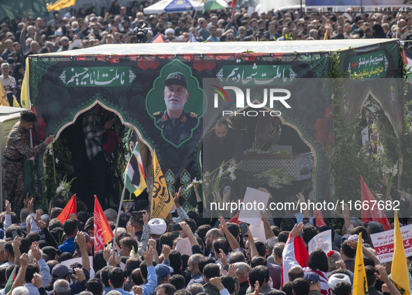 Iranian mourners take part in a funeral while a truck carries a coffin containing the body of a commander of the Islamic Revolutionary Guard...