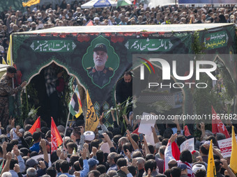 Iranian mourners take part in a funeral while a truck carries a coffin containing the body of a commander of the Islamic Revolutionary Guard...