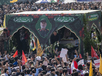 Iranian mourners take part in a funeral while a truck carries a coffin containing the body of a commander of the Islamic Revolutionary Guard...