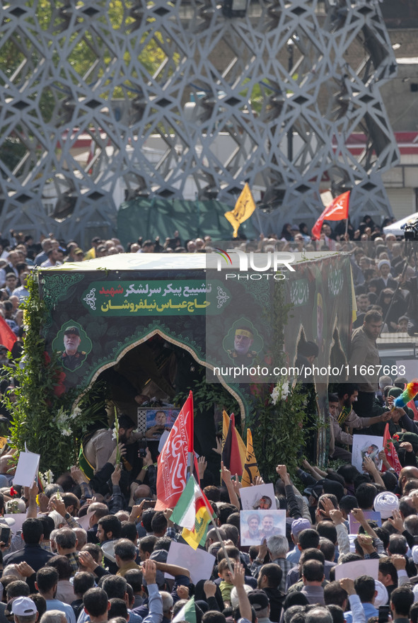 Iranian mourners take part in a funeral while a truck carries a coffin containing the body of a commander of the Islamic Revolutionary Guard...