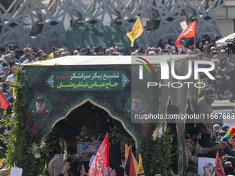 Iranian mourners take part in a funeral while a truck carries a coffin containing the body of a commander of the Islamic Revolutionary Guard...