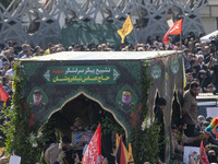 Iranian mourners take part in a funeral while a truck carries a coffin containing the body of a commander of the Islamic Revolutionary Guard...