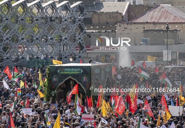 Iranian mourners take part in a funeral while a truck carries a coffin containing the body of a commander of the Islamic Revolutionary Guard...