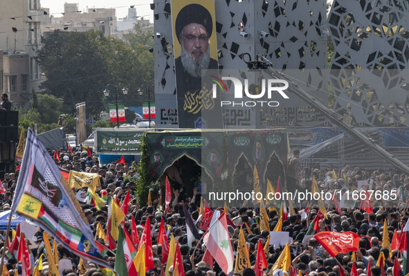 Iranian mourners take part in a funeral while a truck carries a coffin containing the body of a commander of the Islamic Revolutionary Guard...