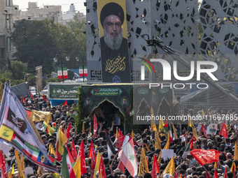 Iranian mourners take part in a funeral while a truck carries a coffin containing the body of a commander of the Islamic Revolutionary Guard...