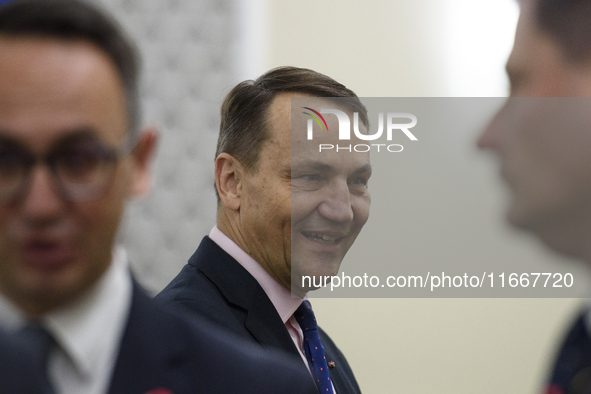 Polish Minister of Foreign Affairs Radoslaw Sikorski talks as he arrives at the weekly Ministerial meeting in Warsaw, Poland, on October 15,...