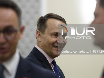 Polish Minister of Foreign Affairs Radoslaw Sikorski talks as he arrives at the weekly Ministerial meeting in Warsaw, Poland, on October 15,...