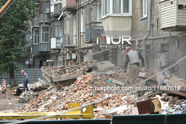 Workers are at a pile of rubble at the apartment block in Vokzalna Square that is being dismantled in Dnipro, Ukraine, on October 14, 2024....