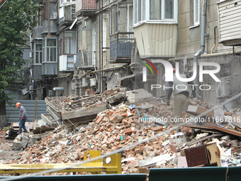 Workers are at a pile of rubble at the apartment block in Vokzalna Square that is being dismantled in Dnipro, Ukraine, on October 14, 2024....