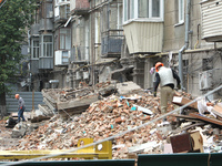 Workers are at a pile of rubble at the apartment block in Vokzalna Square that is being dismantled in Dnipro, Ukraine, on October 14, 2024....