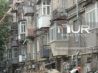 A worker is at a pile of rubble at the apartment block in Vokzalna Square that was hit by a Russian missile on April 19, 2024, and is being...