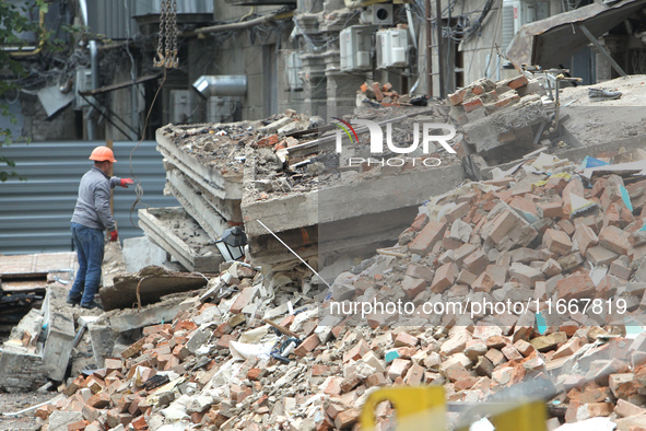 A worker is at a pile of rubble at the apartment block in Vokzalna Square that was hit by a Russian missile on April 19, 2024, and is being...