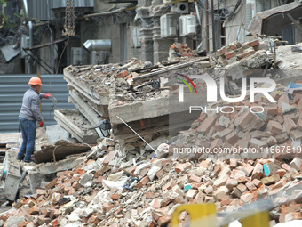 A worker is at a pile of rubble at the apartment block in Vokzalna Square that was hit by a Russian missile on April 19, 2024, and is being...