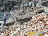 A worker is at a pile of rubble at the apartment block in Vokzalna Square that was hit by a Russian missile on April 19, 2024, and is being...