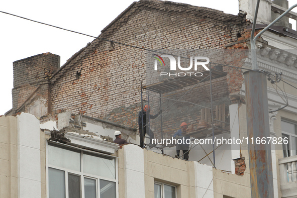 Workers are at a pile of rubble at the apartment block in Vokzalna Square that is being dismantled in Dnipro, Ukraine, on October 14, 2024....