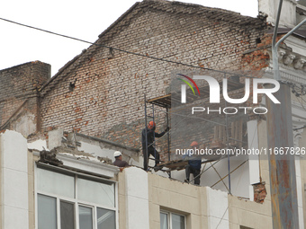 Workers are at a pile of rubble at the apartment block in Vokzalna Square that is being dismantled in Dnipro, Ukraine, on October 14, 2024....