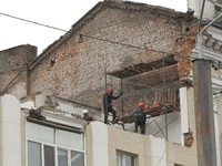 Workers are at a pile of rubble at the apartment block in Vokzalna Square that is being dismantled in Dnipro, Ukraine, on October 14, 2024....