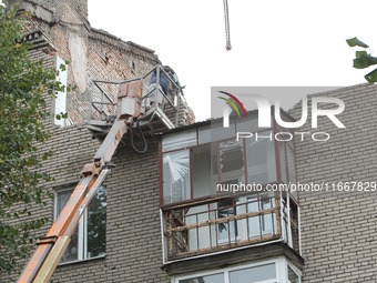 Workers are at a pile of rubble at the apartment block in Vokzalna Square that is being dismantled in Dnipro, Ukraine, on October 14, 2024....