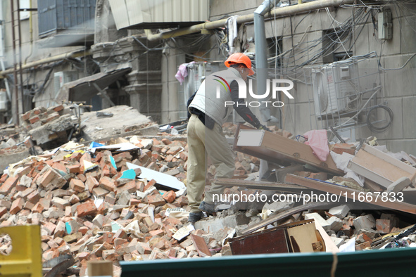 A worker is at a pile of rubble at the apartment block in Vokzalna Square that was hit by a Russian missile on April 19, 2024, and is being...