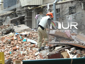 A worker is at a pile of rubble at the apartment block in Vokzalna Square that was hit by a Russian missile on April 19, 2024, and is being...