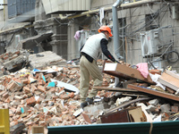 A worker is at a pile of rubble at the apartment block in Vokzalna Square that was hit by a Russian missile on April 19, 2024, and is being...