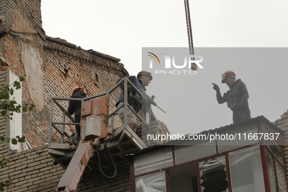 Workers are at a pile of rubble at the apartment block in Vokzalna Square that is being dismantled in Dnipro, Ukraine, on October 14, 2024....