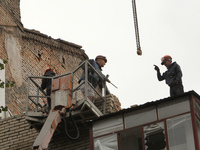 Workers are at a pile of rubble at the apartment block in Vokzalna Square that is being dismantled in Dnipro, Ukraine, on October 14, 2024....