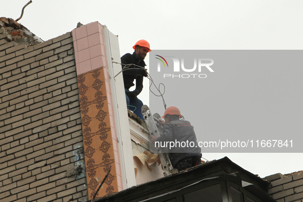 Workers are at a pile of rubble at the apartment block in Vokzalna Square that is being dismantled in Dnipro, Ukraine, on October 14, 2024....